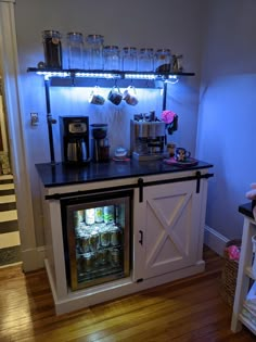 an open refrigerator in the corner of a room with shelves and jars on top of it