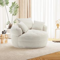 a living room with a large white round chair in the center and a plant behind it