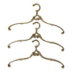 an antique brass coat rack with three hooks