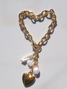 "This Sylvie Gabrielli My Only Heart Bracelet is a beautiful handmade accessory composed of freshwater pearls and a vintage heart charm. The combination of these quality materials makes this a timeless piece that is sure to be treasured for years to come. My Only Heart Bracelet features a plated gold link chain, drops of Freshwater Pearls with a Vintage Heart Charm.Features:- Authentic Vintage Gold Heart Bead- Freshwater Pearls- Lobster ClaspDimensions:-Length: 7.5\"-Extension: 2\"- Heart Diamet Gold Heart-shaped Pearl Bracelet For Valentine's Day, Pearl Bracelets With Heart Beads, Gold Pearl Bracelet With Heart Charm As Gift, Gold Pearl Bracelet With Heart Beads For Valentine's Day, Elegant Pearl Heart Bracelet With Charm, Gold Pearl Bracelet With Heart Charm, Gold Heart-shaped Pearl Bracelet With Heart Beads, Gold Pearl Bracelet With Heart Beads, Handmade Elegant Pearl Bracelet For Valentine's Day