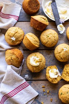 several muffins on a wooden table with butter and other food items around them