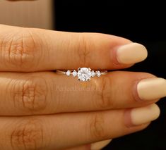 a woman's hand with a diamond ring on it