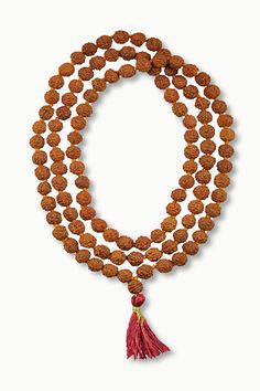 This simple hand-crafted mala featuring a deep red tassel, is made of 108 knotted Rudraksha seed beads and is perfect for your everyday ritual and mediation. Legend has it that the first Rudraksha seeds were created from tears of Lord Shiva as they fell on the earth and formed into a tree. Rudraksha seeds have wonderful spiritual and medicinal properties and, you can feel their power as you count through the beads one by one to recite your chosen mantra or intention. The number 108 holds spiritu Traditional Mala With Gemstone Beads For Healing, Spiritual Gemstone Beads Mala For Puja, Spiritual Gemstone Mala For Puja, Spiritual Round Beads Mala For Puja, Red Mala For Meditation With Round Beads, Spiritual Mala With Round Beads For Puja, Hand-strung Spiritual Mala For Puja, Spiritual Mala For Puja With Round Beads, Red Round Beads Mala For Meditation