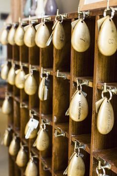 a bunch of bells are hanging on the wall in a room that is filled with key chains