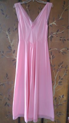 "70s gorgeous bubblegum pink nylon maxi slip / nightie by Vanity fair. The bust has delicate embroidered flower detail. Waist is accentuated with a deep V and a maxi length skirt part. Sheer hem and shoulder straps. **just very light 'scratch' marks on bottom of skirt but barely visible** Size 36 Nylon Length 55\", waist 28\" Made by vanity fair" Pink V-neck Sundress Maxi Dress, Feminine V-neck Nightgown For Spring, Pink Feminine Maxi Dress With Spaghetti Straps, Summer V-neck Stretch Nightgown, Sleeveless Stretch Nightgown For Spring, Feminine Pink Maxi Dress With Spaghetti Straps, Spring V-neck Stretch Nightgown, Pink V-neck Stretch Maxi Dress, Solid Color Spring Nightgown For Daywear