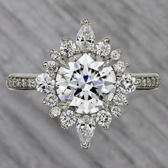 an engagement ring with a large diamond surrounded by smaller diamonds