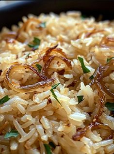 rice with onions and herbs in a black bowl