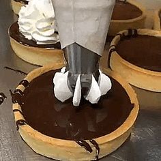 chocolate covered desserts with whipped cream in the middle and on top are being piped together