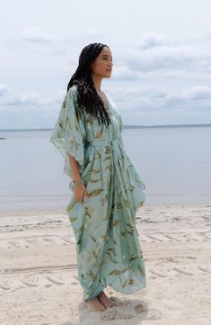 Perfect for poolside hangs or kicking it in the sand, this tie-front kaftan is the perfect accessory to add to your sun-loving wardrobe. V-neck Short sleeves 100% polyester satin Hand wash, line dry Imported Model stats: 5'10", 32" bust, 25" waist, 36" hip. Model is wearing size One Size. Plus Size Caftans, Kaftan Dress Modern, Kaftan Styles For Ladies, Kaftan Styles, Beach Kaftan, Satin Hands, Caftan Dress, Beach Photoshoot, Modern Dress