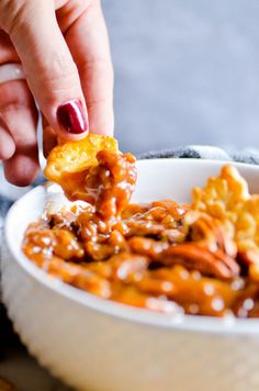 a person dipping some food into a bowl