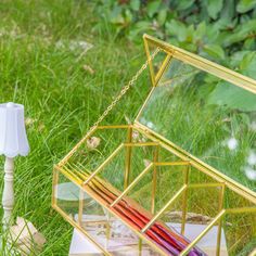 a glass box sitting on top of a wooden table next to a white light bulb