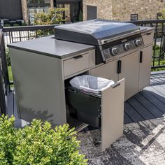 an outdoor kitchen with a trash can and grill