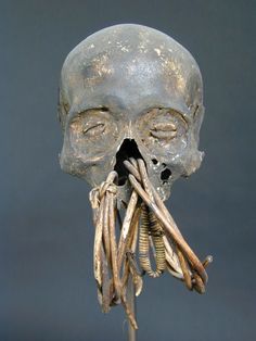 an odd looking human head with long nails in it's mouth