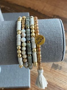 This 4mm gray stack consists of 5 bracelets, perfect for everyday wear and every occasion.  *In this stack you will receive* * 2 Heishi bracelets with gold round beads and an S&L charm.   * Brown Spotted beads with a light gray tassel.  * Natural stone bead in clear and gray with gold spacers.  * Bamboo Leaf bead with gold accent.   All S&L Stackz come in a muslin bag for easy storage and gifting! If you need a special gift for that someone, these stacks are perfect!  Bracelets are made with quality stretchy elastic material. Heishi bracelets have double elastic.  >> Try rolling one bracelet at a time << >>Do not over stretch<< > Please keep in mind, this stack is made to order. FINAL SALE > Color & size of beads may vary due to supply.  > Follow instructions of care. Keep away from water Stretch Beaded Bracelets Diy, Heishi Jewelry, Heishi Bracelets, Stackable Beaded Bracelets, Stack Bracelet, Bracelets Design, Gold Armband, Beads Bracelet Design, Beaded Bracelets Diy