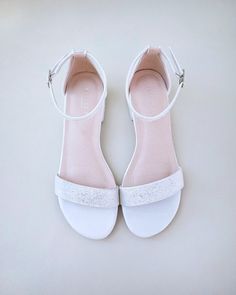 a pair of white shoes with jewel embellishments