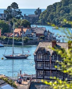 a boat is in the water next to some buildings and trees with houses around it