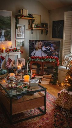 a living room decorated for christmas with candles and pictures on the wall behind the fireplace