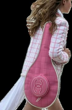 a woman walking down the street with a pink bag on her back and one hand in her pocket