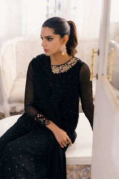 Traditional Black Chiffon Embroidered Pakistani Salwar Kameez Suit an alluring dress in a captivating black tone. The sequin-studded chiffon shirt boasts a lavish hand-embellished neck patch, creating a dazzling design. Adorned with cutwork organza lace, the sleeves and front border exude elegance and sophistication. Chiffon Kameez: The beautiful kameez comes in an Jet Black color and is adorned with intricate designs and fine details of embroidery. The fabric of this embroidered kameez is premium Chiffon. Sequins, floral motifs, tilla, Resham, and beaming ornaments give a perfect finishing look to this kameez. Silk Trouser: The embroidered organza kameez is Paired seamlessly with raw silk bottoms. The trousers come in premium raw silk fabric and they look perfect with the intricately embe Black Semi-stitched Salwar Kameez For Party, Black Semi-stitched Salwar Kameez With Zari Work, Elegant Embroidered Black Salwar Kameez, Unstitched Black Embroidered Salwar Kameez, Walima Dresses Pakistani, Bridal Lehenga Indian, Semi-stitched Embellished Black Salwar Kameez, Pakistani Mehndi Dress, Party Wear For Women