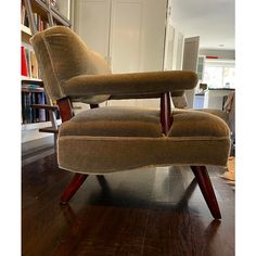 a chair that is sitting in the middle of a room with bookshelves behind it