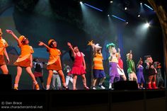 a group of people standing on top of a stage with their arms in the air