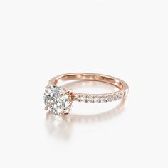 a rose gold engagement ring with an oval cut diamond in the center and side stones