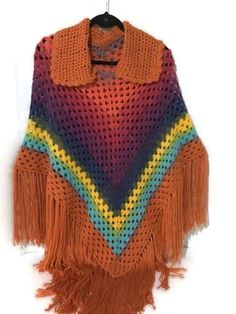 The poncho is a versatile garment, it can be wear over a pair of jeans and a sweater, or over a jacket, to keep you warm and cozy. I crocheted the poncho with a self striped acrylic yarn with gradients colors running from orange, brick, grape, blue, yellow, green, to brown. It has a collar and fringes. FLAT PONCHO MEASUREMENTS: A. Base of the neck to drop of shoulder: 22.5 Inches (without fringes length) B. Base of the neck to drop of neckline: 5.5 Inches ( neck opening is 22 inches..5.5x4) C. D Orange Poncho, Orange Brick, Gradient Yarns, Crochet Poncho, Yarn Colors, Acrylic Colors, Gradient Color, Acrylic Yarn, Warm And Cozy