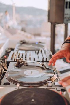 a dj mixing music on top of a turntable