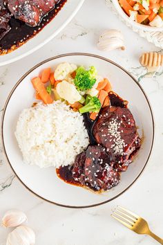 a plate with meat, rice and vegetables on it next to other plates full of food