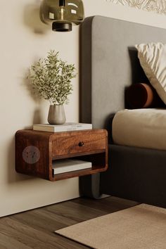 a nightstand with a potted plant on it next to a bed