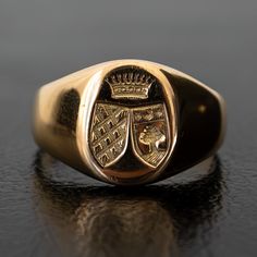 A regal engraving of two crests beneath a crown adorns the signet of this unique vintage ring. Substantial and prestigious, this ring feels both historic and fashion-forward. The thick band tapers in the back for an everyday comfortable fit. Metal: 18k Yellow GoldMeasurements: Width: 12-2mm Size 6.25 in stock Shipping and Delivery: IN STOCK items will ship within 2 business days Sizes not In Stock will be Resized Resize Fee may apply Please allow 2 weeks for delivery All Resize items are final s Antique Signet Ring With Polished Finish For Formal Occasions, Luxury Formal Signet Ring With Intaglio, Luxury Engraved Signet Ring For Formal Occasions, Classic Hallmarked Signet Ring For Collectors, Classic Hallmarked Signet Ring Collectible, Classic Yellow Gold Signet Ring With Intaglio, Formal Gold Signet Ring With Coat Of Arms, Antique Hallmarked Signet Ring For Formal Occasions, Timeless Formal Engraved Ring With Hallmarks