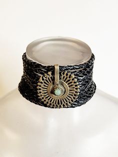 Discover the enchanting allure of our one-of-a-kind bohemian choker, meticulously handcrafted for the empowered woman with a penchant for unique style. This exquisite piece features a vegan braided leather band that gracefully adorns your neck, offering a comfortable and ethical fashion choice. At the heart of the choker lies an antique tribal central piece, boasting a stunning piece of jade with a rich history that adds depth and storytelling to your ensemble. Measuring at a versatile length, t Bohemian Choker With Unique Variations, Handmade Adjustable Choker For Festivals, Bohemian Festival Choker Jewelry, Handmade Bohemian Brass Choker, Black Bohemian Choker, Unique Boho Collar Jewelry As Gift, Unique Boho Collar Jewelry, Adjustable Bohemian Jewelry For Ceremonies, Bohemian Brass Choker Jewelry