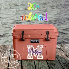 an orange yeti cooler sitting on top of a wooden dock next to the water