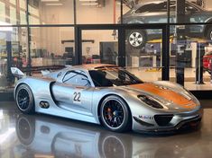 a silver and orange sports car in a showroom