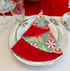 the place setting is decorated with red and green napkins