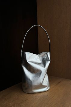 Silver leather bucket bag featuring a scrunch silhouette and tall top handle. Inside features tie strap for closure and is lined with cotton. Fit True to size Composition 100% Leather (Outer) 100% Cotton (Inner) This product is final sale Round Bucket Bag, Silver Pouch Bag, Mood Inspiration, Barrel Bag, Leather Bucket Bag, Leather Bucket, Basket Bag, Nylon Bag, Pouch Bag