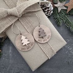 two wooden christmas ornament hanging from a gift box