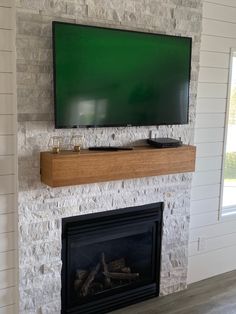 a flat screen tv mounted above a fireplace