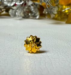 a close up of a ring on a table with flowers in the backgroud