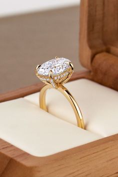 a diamond ring sits in a wooden box