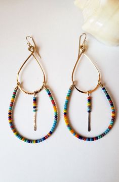 "A double tier design that's flattering on all face shapes. These are bold, fun and lightweight.  Earrings are done in your choice of metal, red brass, or silver-filled (heat bonded sterling silver to a base metal). They hang approximately  4\" total with earwires. Wear these for some unassuming sexines and fun." Brass Jewelry With Tiny Beads In Dangle Shape, Everyday Multicolor Heishi Beads Jewelry, Fun Nickel-free Metal Jewelry, Colorful Bohemian Hoop Jewelry, Handmade Adjustable Fun Beaded Earrings, Bohemian Heishi Beads Hoop Earrings As Gift, Gold Heishi Beaded Earrings With Colorful Beads, Bohemian Heishi Beads Hoop Earrings, Bohemian Hoop Beaded Earrings With Heishi Beads