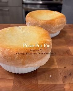 two small pies sitting on top of a wooden cutting board next to each other