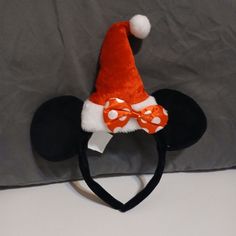 an orange and white mickey mouse ears hat on top of a black minnie mouse headband