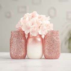 pink flowers are placed in mason jars on a white countertop, with the words mason written above them