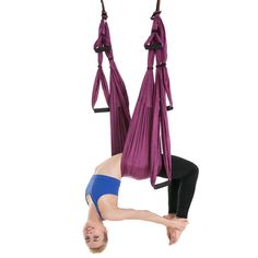 a woman is doing aerial acrobatics on a hammock