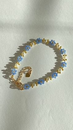 a blue and gold beaded bracelet on a white surface