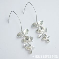 A beautiful pair of linear dangle earrings with rhodium-plated (white gold) V-shaped earwires suitable for sensitive skin.  Attractive shiny silver-plated triple tier orchid flowers.  Comes gift wrapped ready for gift giving.♥ Rhodium-plated (white gold) V-shaped linear earrings (approx. 35mm length)♥ Silver-plated triple orchid dangling charms (approx. 35mm)♥ Always gift wrapped ♥[ Matching necklace also available separately ]______________________________________________________________Follow Silver Minimalist Dangle Flower Earrings, Silver Dangle Flower Earrings Minimalist Style, Hypoallergenic Sterling Silver Flower Earrings For Wedding, Minimalist Sterling Silver Flower Earrings For Wedding, Silver Flower Shaped Hoop Earrings For Wedding, Elegant Flower Shaped Earrings With French Hook, Elegant Floral Earrings With French Hook, Silver Teardrop Flower Earrings For Party, Sterling Silver Dangle Flower Earrings For Wedding