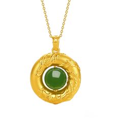 a gold necklace with a green stone in the center and an ornate design around it