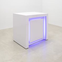 a white box with blue lights on it in the middle of an empty floored room