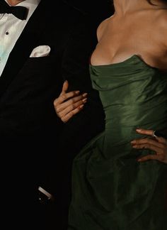 a woman in a green dress and a man in a tuxedo